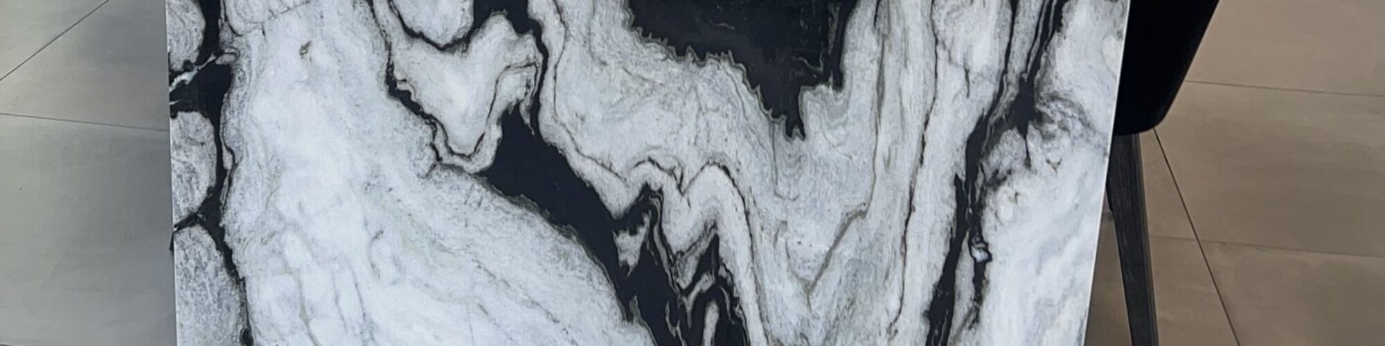 The mitred corner of a marble table, the veining carried from the top down the end panel