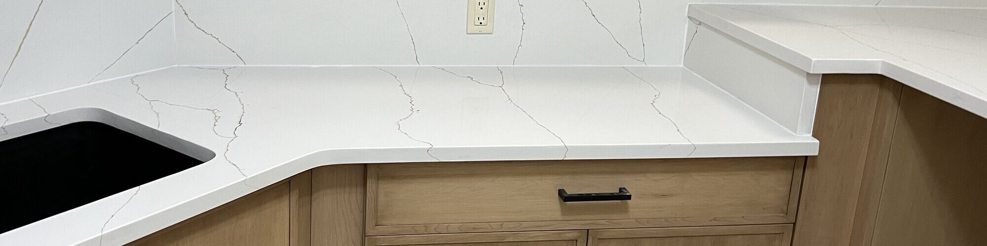 A full-height stone backsplash meeting the counter it was cut to match
