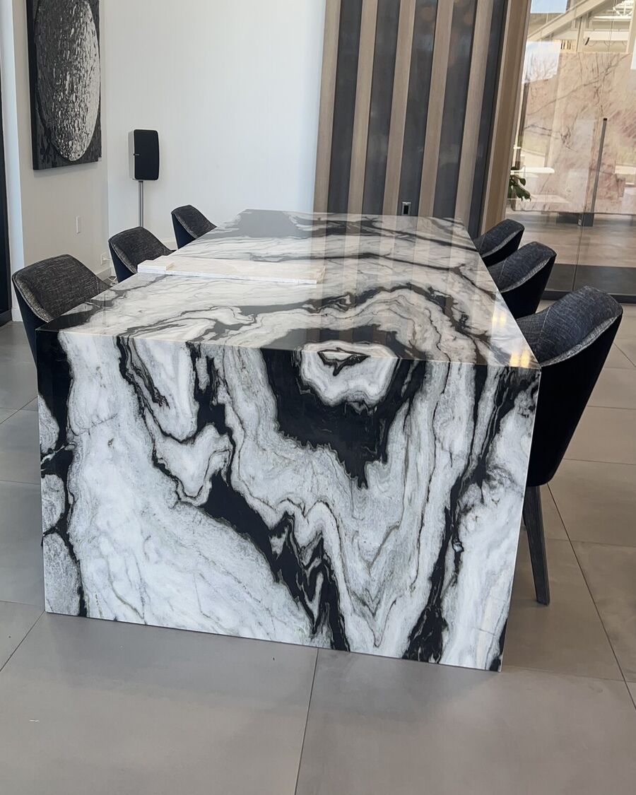 A bookmatched marble dining table with a full waterfall edge, cut and finished by Beautiful Granite & Marble