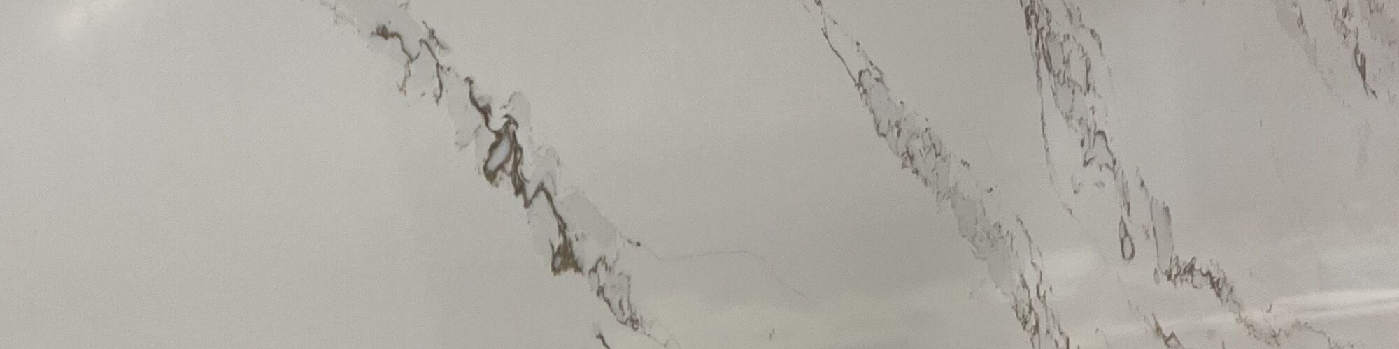 A white quartz slab with fine, evenly spread veining